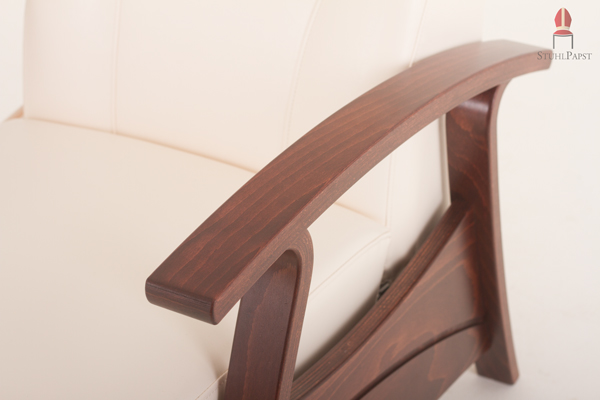 Die formschönen Armlehnen in dunklem Holz