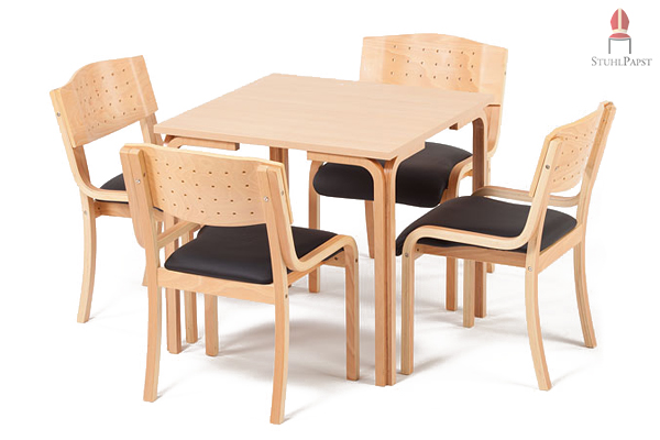 Hier sehen Sie das Tischmodell Com.fort in Kombination mit einem gepolsterten Holzstuhl